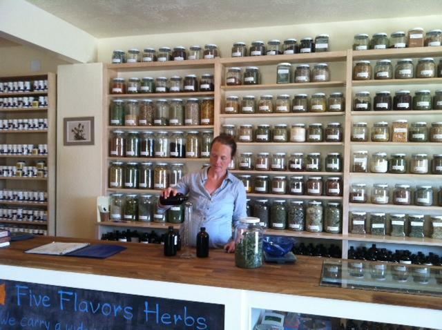 Pouring tinctures in front of the bulk Western herb apothecary