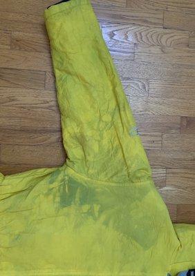 One sleeve showing the tie die green effect on a once brilliant yellow coat due to lining bleed.