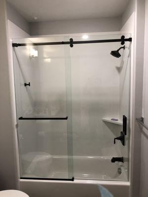 Barn door shower enclosure with towel bar.