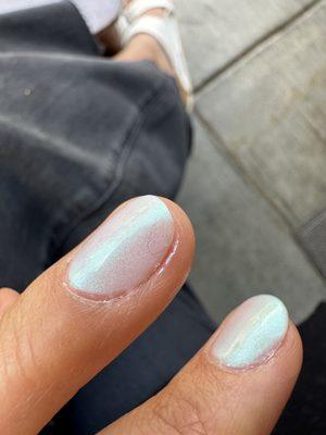 Small piece of fuzz stuck in polish on the left hand nail