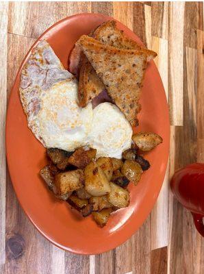 Over easy eggs, ham, home fries and toast.