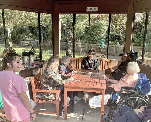 Residents and staff enjoy a game of cards in the gazebo (pre-pandemic)