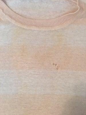 Large pale yellow stain and holes that were not there before the dry cleaner. No mention of either when item picked up.