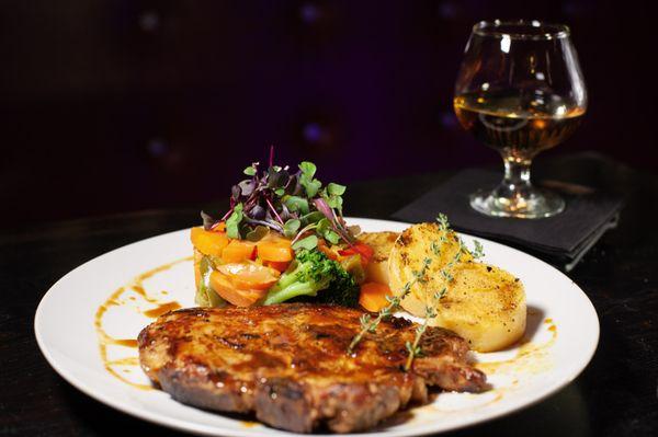 marinated pan seared Pork Chop served with baby polenta cakes, vegetable of the day, drizzled with house pork chop glaze