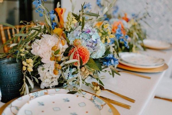 Flower runner Positano themed. Blues and oranges with hydrangeas, dahlias, garden roses and olive branches.