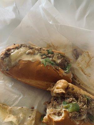 Philly cheesesteaks with onions peppers cheese and wine sauce