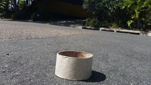 The cardboard roll from the tape used.  You can plainly see storm drain in background