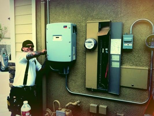 Josh installing an SMA Sunny Boy inverter that converts the DC power created by the panels to AC power.