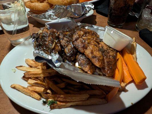 Jamaican chicken fingers with a side of French fries.