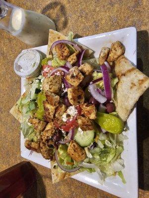 Chicken Souvlaki salad.  Dressing on the side in a carafe.  Also, a small container of Tzatziki