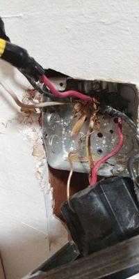 Unsafe wiring found behind stove and repaired.