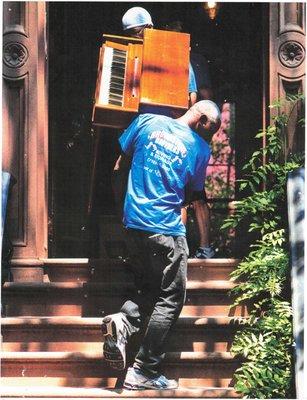 Brownstone Brothers Moving carefully moving a piano into it's new home.