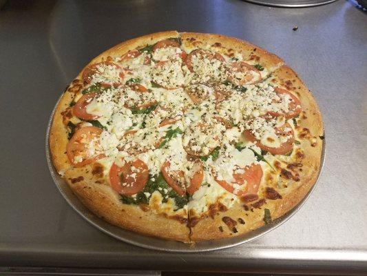 Greek Specialty, garlic base with spinach, tomatoes, mozzarella and feta cheese with Mediterranean spices for $18.99