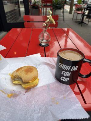 Breakfast sandwich, sausage egg and cheese sandwich, hot coffee, outside seating