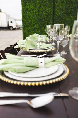 Farm table set up with chinaware, flatware and glassware