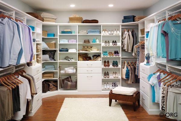 Standard white walk-in closet with hamper, tilted shoe racks, drawers, and hutch