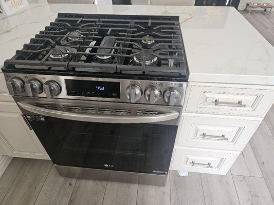 Oven/stove combo installed with new cabinets surrounding it.