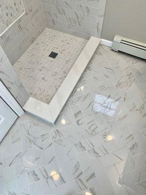 Custom floor tile custom shower pan with marble saddle or material purchased from Floor Decor