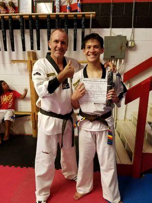 Evan Reed with Master Main, Evan got promoted with a jr black belt .