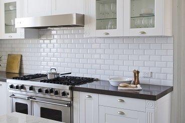 White shaker cabinets, trim pieces, glass doors, subway tile.