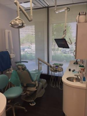 Exam room with a TV/Monitor and exam chairs with a massage feature.