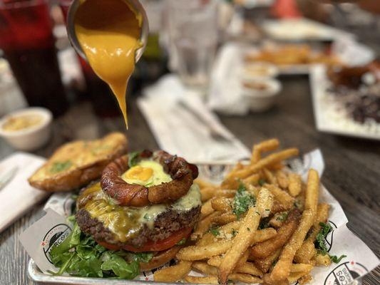 Cheesunami burger with truffle fries. Bacon wrapped onion ring on a cheeseburger comes with cheese sauce to pour on top.  so good.