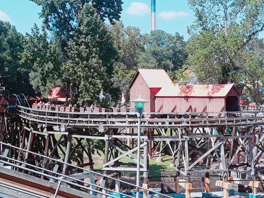 A train disengages the 3rd of 3 lift hills and prepares to enter an elevated, covered tunnel before dropping underground