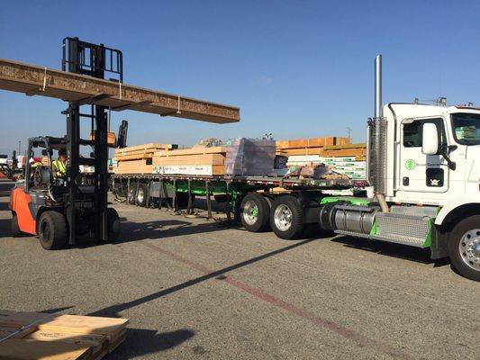 Forklift loading engineered wood products on to flat bed trailer at Dixieline National City production lumberyard.