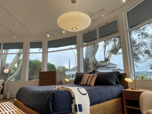 Large Eames light hanging over a queen size bed.