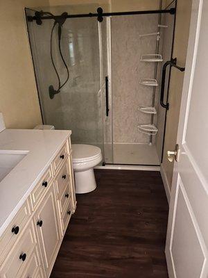 Bathtub/ shower converted to shower stall and new vanity on new laminate flooring