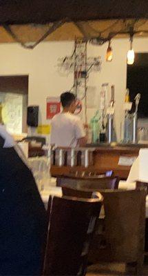 An employee that was off behind the bar pour himself a beer in a crab shack cup bye he was also vaping in the restaurant