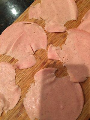 Hacked up bologna.  Not all deli clerks are good.  This happens too often when I order online.  Cutting dull blade.