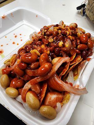 Tostilocos: cuernitas pickled porkstrips, Japanese peanuts, peanuts, jicama and cucumber, chamoy candy bits, doritos, sour spicy red sauce