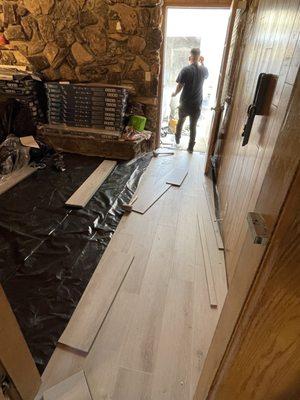 Installing your flooring in the den with the moisture plastic on the ground because of concrete