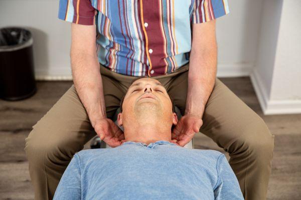 Dr Elon Bartlett massaging the neck to relax the patient before an adjustment.