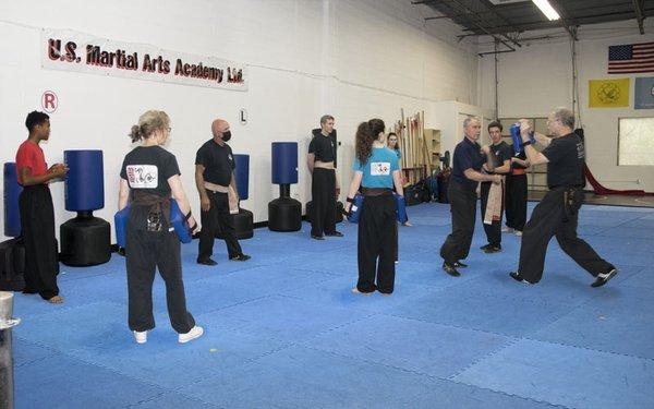 Adult and 16+ year olds in Adult Kung Fu class learning self-defense with partner drills