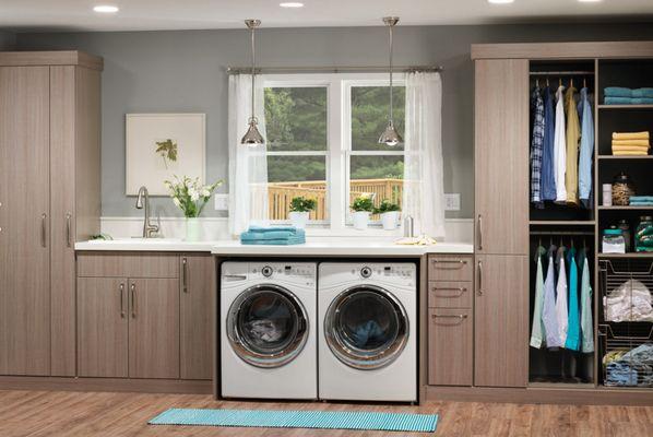 Custom laundry room with ample storage, countertop for folding clothes, and and tall cabinets for cleaning items