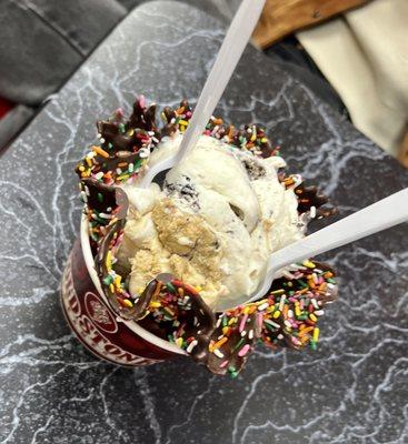 Chocolate dipped waffle cone with cookies and crème and cookie dough topping mixed in