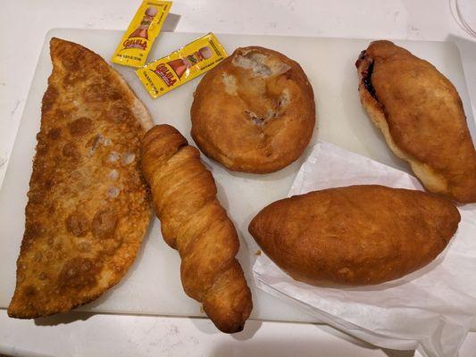 From left: cheburek (huge at about 8 inches), pig in a blanket, belyash, cabbage, egg and cheese, and jam piroshki.