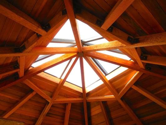 Custom triangular glass skylight over exposed rafters in Master Bedroom