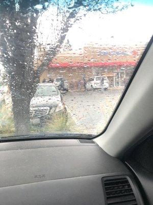 People waiting in line in the rain behind cars almost getting ran over!