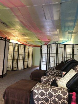 Main room with screens for individual work semi-private areas for four massage tables