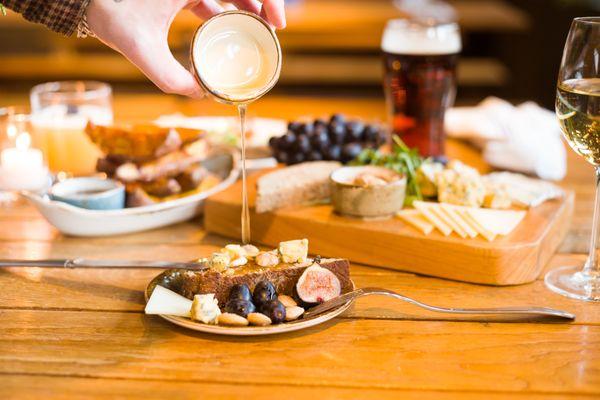 Cheese Board- Roquefort, Manchego, Taleggio, grapes, local honey, figs, Marcona almonds, toasted brewery-grain bread.