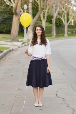 White lace crop top paired with navy flare skirt