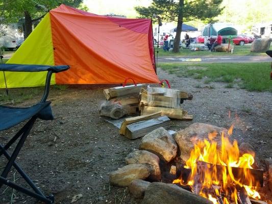 Chilling by the fire near the tarp shelter