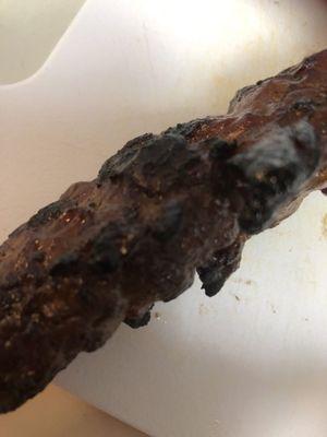 Burnt on the outside BBQ pork skewer