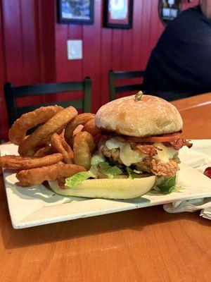 Fried chicken sandwich with bacon, cheese curd, lettuce, tomato and habanero bacon jam. Paired with onion rings