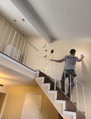 StudFinder, making sure he doesn't drill into a pipe/electrical. Moved single loft light to above stairs. 2 way switch at bottom of stairs