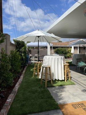 Cocktail table with market umbrella and natural barstools