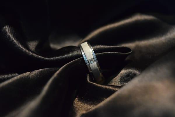 Men's wedding band in white gold with princess cut diamond in center.